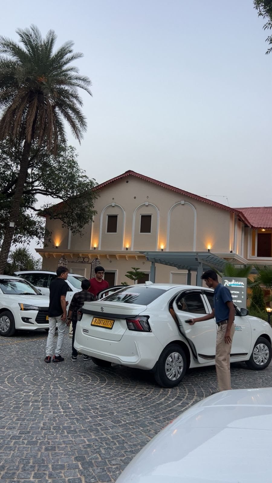 Professional chauffeur assisting passengers at Radisson Resort Mount Abu