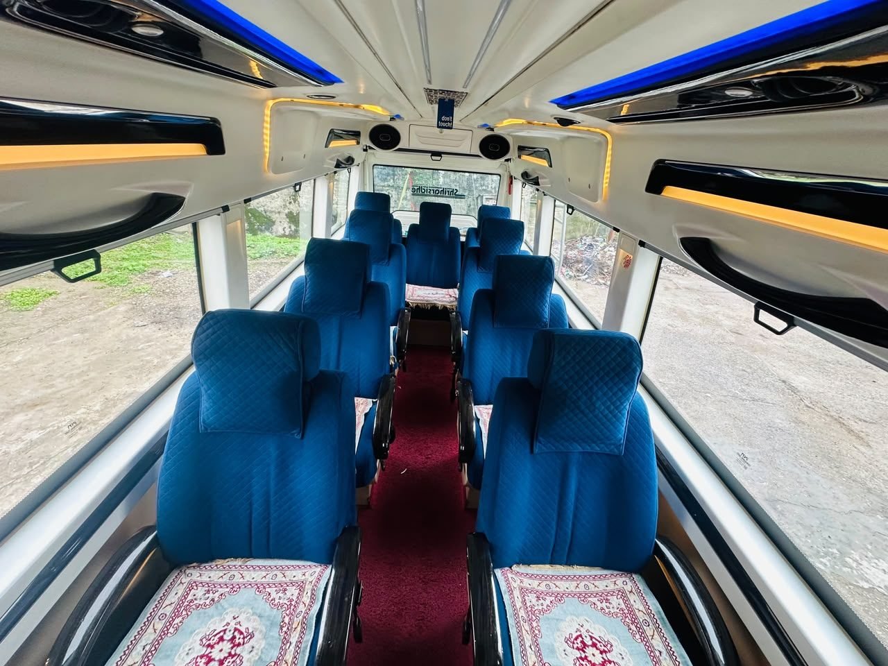 Luxury interior seating and ambient lighting of Tempo Traveller