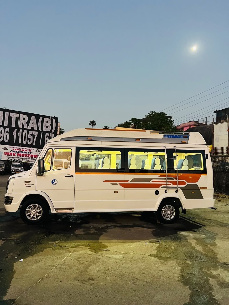 Force Tempo Traveller with orange and gold graphics in Mount Abu